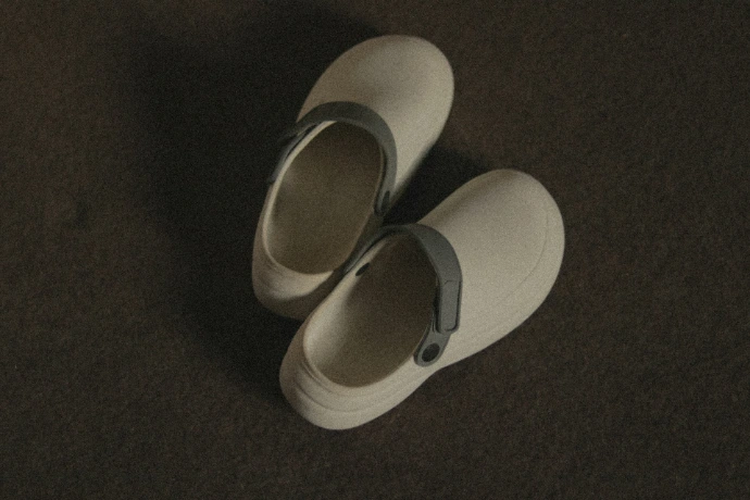 a pair of white shoes sitting on top of a carpet